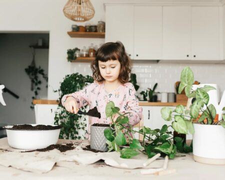 little girl watering indoor plants