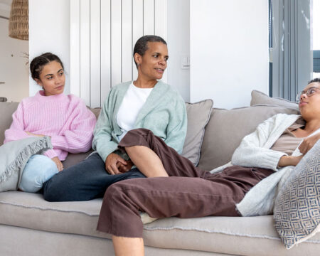mom showing how to talk to teens about substance use sitting with her daughters on the couch