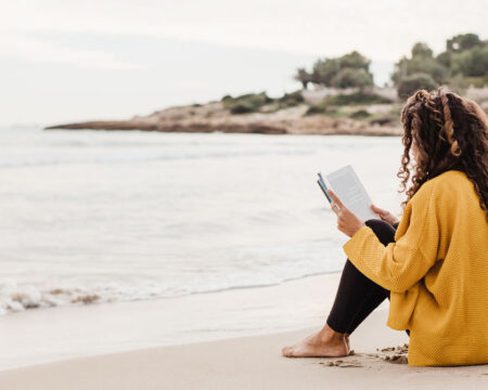 woman reading on the beach by herself