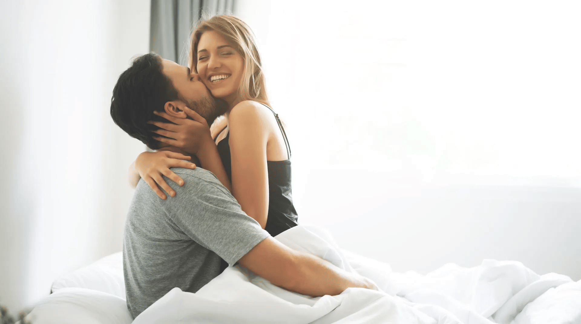 couple in bed smiling kissing 1